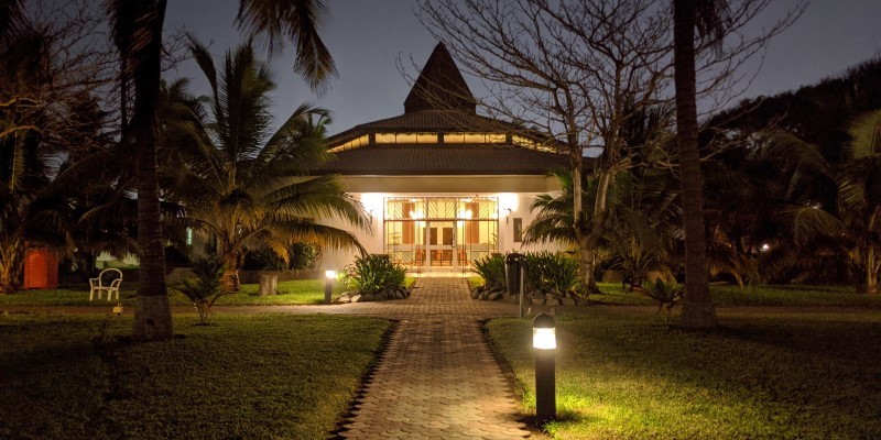 brown and white house in accra ghana surrounded by trees at night time